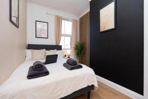 a bedroom with a bed with towels on it at Open Mind Property - Cozy 4BR Flat & 12 Guests in Littlehampton +31 photos