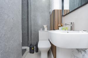 a bathroom with a white toilet and a sink at Open Mind Property - Cozy 4BR Flat & 12 Guests in Littlehampton
