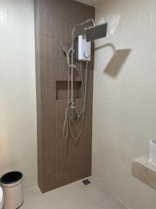 a shower with a shower head in a bathroom at Abundant Eco Hostel in Laguna Phuket