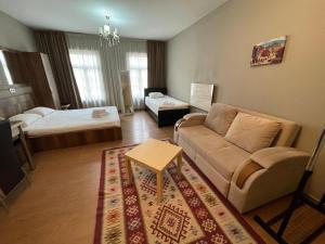 una sala de estar con un sofá y una cama en Apartments by Rikhe Palace, en Tiflis