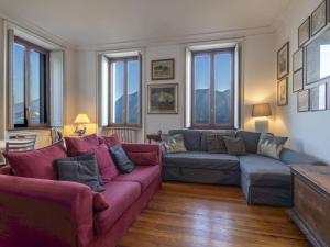 a living room with a purple couch and windows at Apartment Villa Ceriana-5 by Interhome in Ghiffa +29 photos