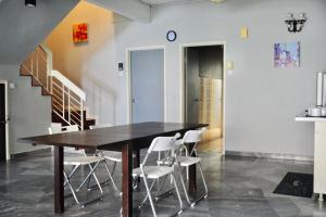 ein Esszimmer mit einem Holztisch und weißen Stühlen in der Unterkunft Grayhaus BU3 House at Bandar Utama - near 1 Utama Shopping Centre - Stay Only NO EVENTS in Petaling Jaya