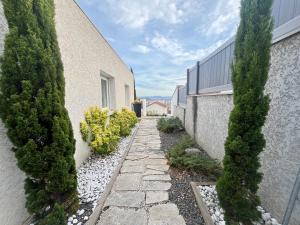 a garden path between two buildings with trees at Maison moderne avec terrasse & parking in Clermont-Ferrand