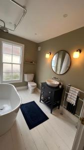a bathroom with a tub and a sink and a mirror at The Locker, 2 bed apartment in Falmouth in Falmouth