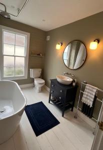 a bathroom with a tub and a sink and a mirror at The Locker, 2 bed apartment in Falmouth in Falmouth +28 photos