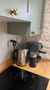 a tea kettle sitting on top of a stove in a kitchen at The Locker, 2 bed apartment in Falmouth in Falmouth