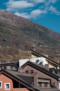 Une montagne au loin avec des maisons et un bâtiment dans l'établissement L'Atelier - 2 min walk to Bernina Express, à Tirano