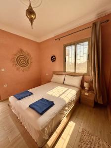 a bedroom with a bed with two towels on it at Dar Iziki Separate Apartments in Sidi Kaouki
