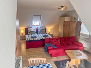 a bedroom with a bed and a red couch at Kröslin Apartments in Kröslin