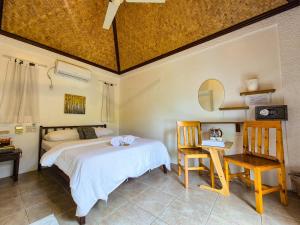 a bedroom with a bed and a table and chairs at SunzEn Palawan, Resort in Coron +25 photos