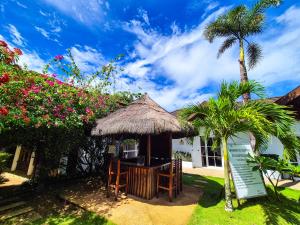 a small hut with a palm tree and flowers at SunzEn Palawan, Resort in Coron