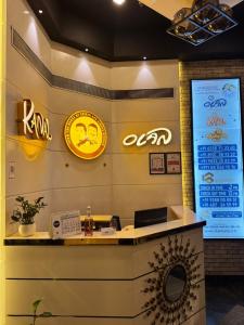 Un mostrador de recepción en un restaurante con carteles en la pared. en 18 Rooms By OLAN, en Trichūr