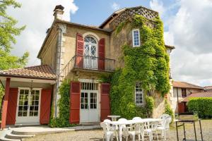 an old house with red doors and ivy at Villa Mon But - Maison de maître du 19ème siècle in Hagetmau