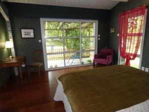 a bedroom with a bed and a large window at Au Bal des Oiseaux in Chavagnes-en-Paillers