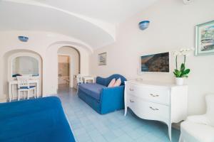 a living room with a blue chair and a couch at Villa La Tartana in Positano