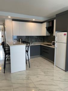 Una cocina con gabinetes blancos y un refrigerador blanco. en A peaceful holiday with a unique view, en Antalya 9 fotos más