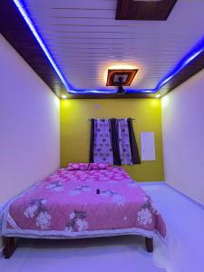a bedroom with a bed with a purple comforter at Juee's Holiday Homes in Alibaug +11 photos