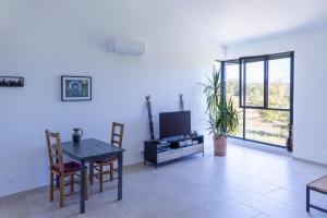 a living room with a table and a tv at Gîte La Mosaïque in Dauphin