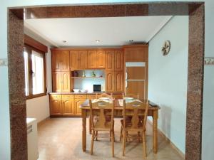 una cucina con mobili in legno, tavolo e sedie in legno di Casa natural redes 