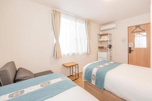 a room with two beds and a couch and a window at Kamakura no Nikki in Kamakura