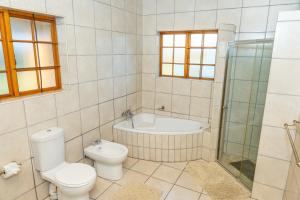 y baño con aseo, bañera y ducha. en Geluk Farmhouse, en Somerset East 16 fotos más