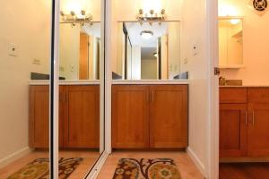 a bathroom with wooden cabinets and a mirror at Kaleialoha 402 · KA 402 Spacious Studio Close to Ocean Heated Po in Kahana +41 photos
