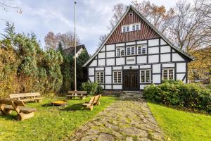 un bâtiment blanc et noir avec bancs devant lui dans l'établissement Hueseken, à Finnentrop