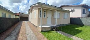 a small house with a lawn in front of it at Casa próximo á Unesc em Criciúma-SC in Criciúma