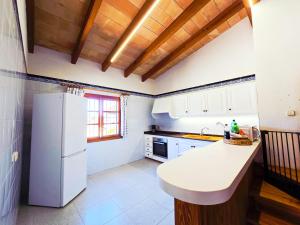 Il comprend une cuisine équipée d'appareils électroménagers blancs et d'un réfrigérateur blanc. dans l'établissement Finca Boy, à Pollença