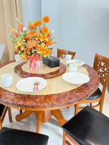 a wooden table with plates and a vase of flowers at Monkey Pool Villa Krabi Ao Nang in Ao Nang Beach +23 photos