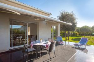 eine Terrasse mit einem Tisch und Stühlen darauf in der Unterkunft Villa Jardins de la Mer in Poggio-Mezzana