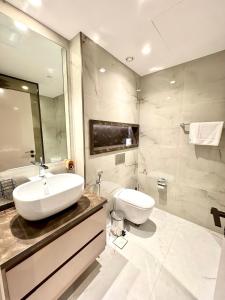 迪拜Burj Khalifa View 2 Bed Luxury Apartment的带水槽和马桶的白色浴室