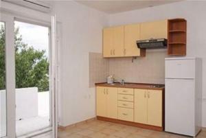 a kitchen with a white refrigerator and a window at Kleines Apartment Emil Vanily in Murter