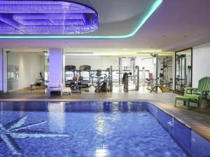 a gym with a swimming pool and exercise equipment at Ibis Styles Dubai Jumeira in Dubai