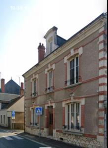 ein Backsteingebäude mit einem blauen Schild davor in der Unterkunft Jolie maison 6 pers spa privé wifi 14 km Beauval in Meusnes + 26 Fotos