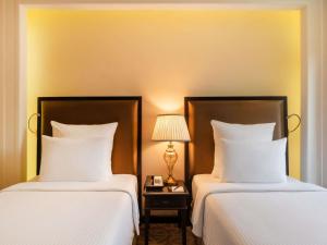 Dos camas una al lado de la otra en una habitación. en Pullman Resort Al Marjan Island, en Ras al Khaimah