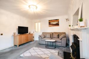a living room with a couch and a tv at Carey House Long Stays Free Parking and WI-FI in Swindon