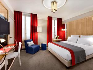 a hotel room with a large bed and a desk at l'Echiquier Opéra Hotel Paris - MGallery Collection in Paris +158 photos