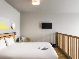 a bedroom with a bed and a tv on the wall at Aparthotel Adagio access Colombes La Défense in Colombes +34 photos