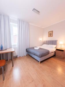 别尔斯克-比亚拉HARCERSKA 7 Pokoje Bielsko Biała的一间卧室，配有一张床、一张桌子和一张书桌 更多77张照片