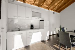 Una cocina con gabinetes blancos y una mesa de comedor. en Kuca za odmor Feniks, en Polača