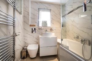 a white bathroom with a sink and a toilet at Carey House Long Stays Free Parking and WI-FI in Swindon +18 photos