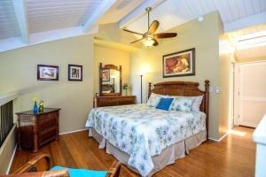 a bedroom with a bed and a ceiling fan at Hale Mahina B401 · HM B401 OceanFront 2BD Tropical Getaway in Kahana +50 photos