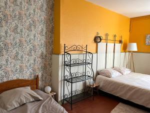 une chambre avec deux lits et des murs jaunes dans l'établissement Le Gué De La Terre, à Saint-Viâtre