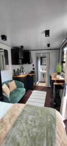 a living room with a green couch and a kitchen at Stacey's Mini Hideaway in Hillcrest
