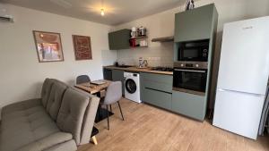 eine Küche mit einem Sofa, einem Tisch und einem Kühlschrank in der Unterkunft Longanea 1 in Saint-Pierre