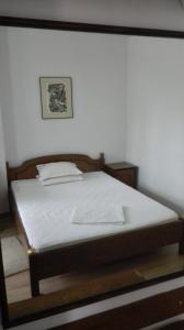 Schlafzimmer mit einem Bett mit weißer Bettwäsche und einem Bild in der Unterkunft Family Hotel Rositsa in Sewliewo