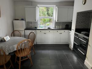een keuken met witte kasten en een tafel en een raam bij 4 Bed in Stokenham oc-i34021 in Stokenham