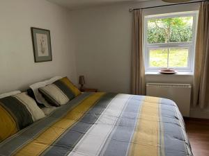een bed in een slaapkamer met een raam bij 4 Bed in Stokenham oc-i34021 in Stokenham