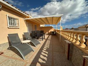 a patio with chairs and a table on a balcony at Tranquilo Townhouse Casa Spain Kwintos in Torrevieja